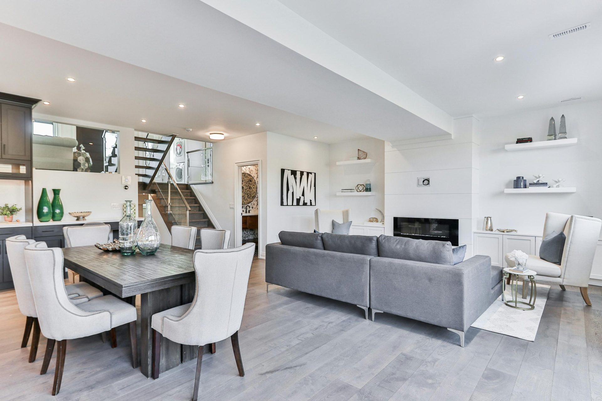 Open-concept living and dining area with gray tones