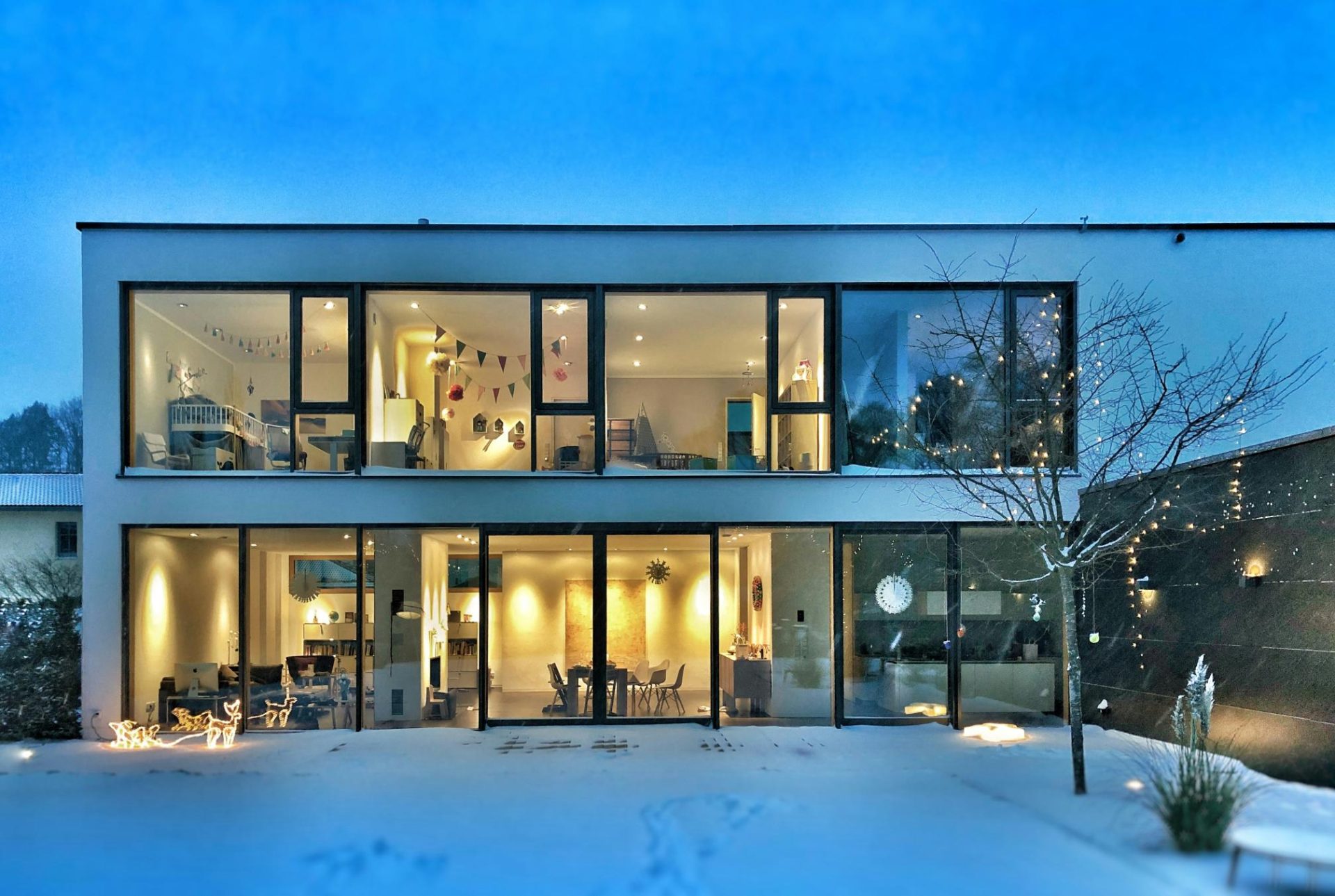 Contemporary glass-front house at dusk