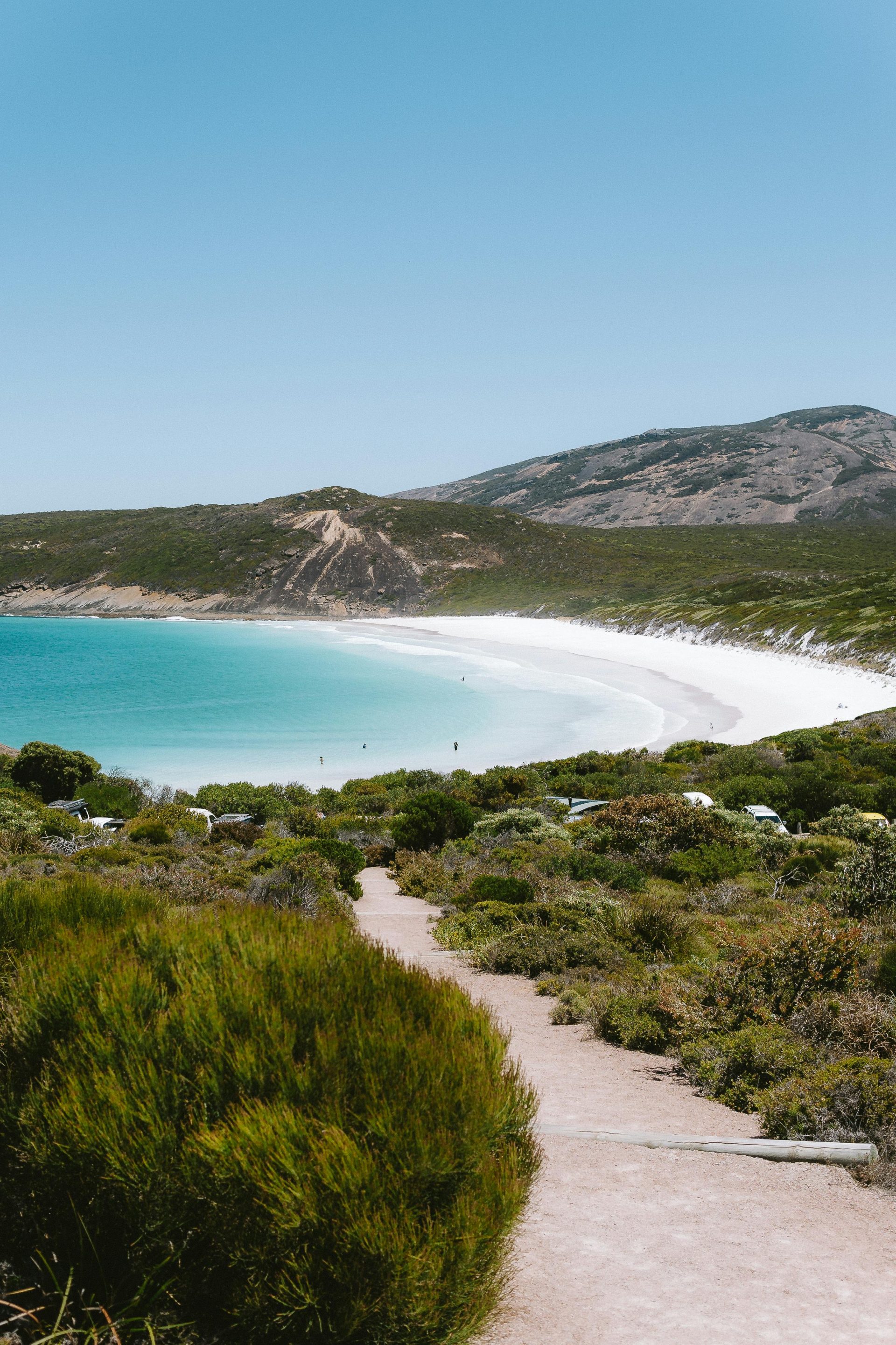 A beach with a white sand and blue water